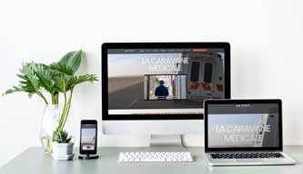 caravane medicale website mockup with flower deco on a table ordi,ipad et mobile
